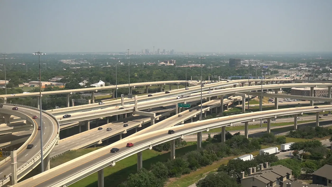 Aerial view of the I-10 and 410 interchange in San Antonio with the downtown skyline beyond, the location SA Cowork sits on