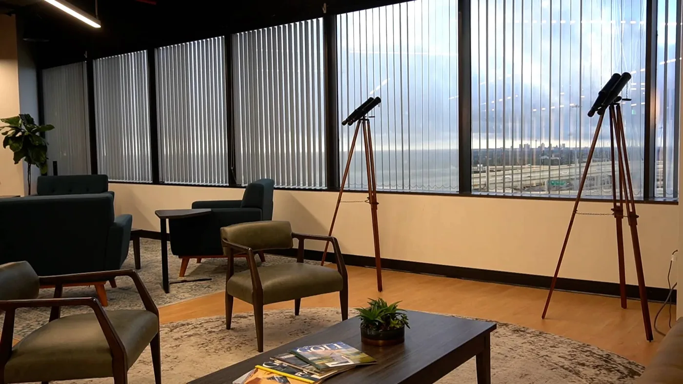The SA Cowork member lounge overlooking I-10, with seating and skyline views for members and their guests